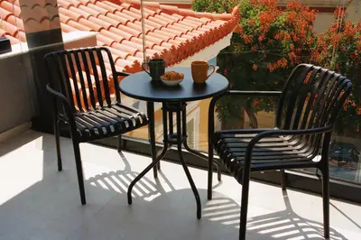 two chairs and a table with two cups on a balcony at Absolute Athens Acropolis Muses in Athens