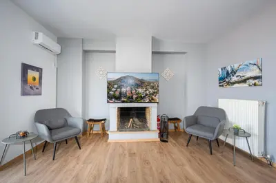 a living room with two chairs and a fireplace at Villa Costa Luca in Vouliagmeni in Athens