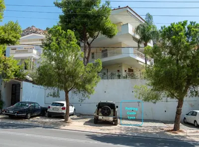 a car parked in a parking lot in front of a building at Villa Costa Luca in Vouliagmeni in Athens