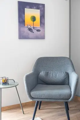 a gray chair in a room with a table at Villa Costa Luca in Vouliagmeni in Athens