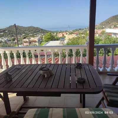a wooden table on a balcony with a view at Skyline Serenity in Lagonissi
