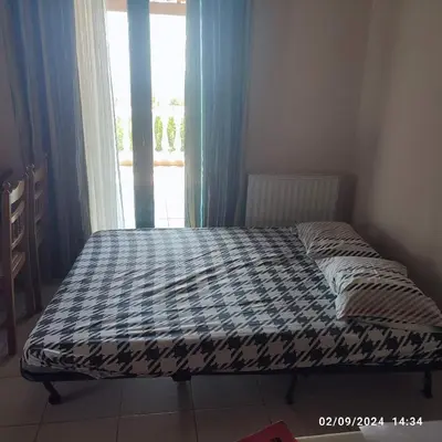 a bed sitting in a room with a window at Skyline Serenity in Lagonissi