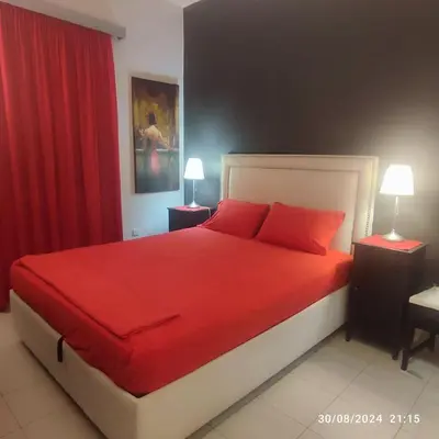 a bedroom with a red bed with two lamps at Skyline Serenity in Lagonissi