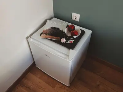 a refrigerator with a cake and fruit on top of it at Cozy Studio in Zografou, close to hospitals in Athens