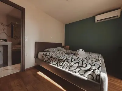 a bed in a room with a green wall at Cozy Studio in Zografou, close to hospitals in Athens