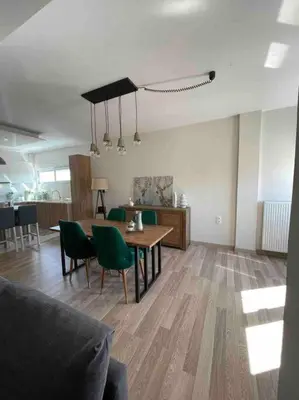 a living room with a table and green chairs at Urban Utopia in Athens