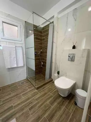 a bathroom with a glass shower and a toilet at Urban Utopia in Athens