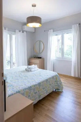 a bedroom with a bed and a mirror and windows at Renovated fully equipped 2 Bedroom cozy Apartment near the sea in Athens