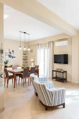 a dining room and living room with a table and chairs at Renovated fully equipped 2 Bedroom cozy Apartment near the sea in Athens