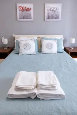 a bed with folded towels sitting on top of it at Renovated fully equipped 2 Bedroom cozy Apartment near the sea in Athens