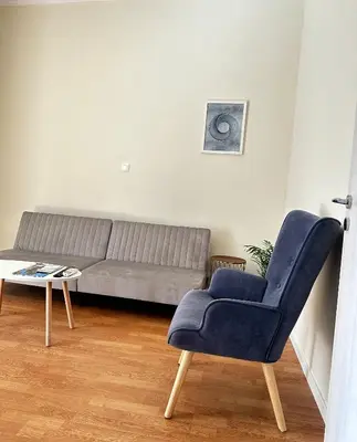 a living room with a couch and a blue chair at Petralona modern apartment near metro & Acropolis in Athens