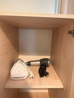 a hair dryer and a blow dryer on a shelf at Petralona modern apartment near metro & Acropolis in Athens