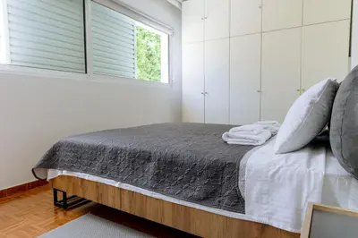 a bedroom with a bed with white walls and a window at Athens Airport Zen House in Paianía