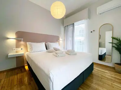 a bedroom with a large white bed with a mirror at Marmaronetta in Athens