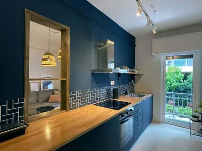 a kitchen with blue walls and a sink and a mirror at Marmaronetta in Athens