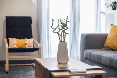 a living room with a vase on a coffee table at Acropolis Walk Residence by MDK Athens in Athens