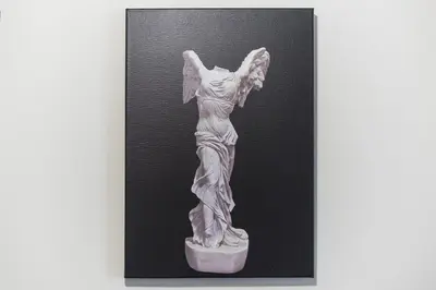 a white statue of a woman on a black background at Acropolis Walk Residence by MDK Athens in Athens
