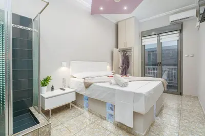 a bedroom with two beds and a glass shower at Gazi Suite with Private Rooftop in Athens