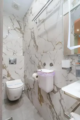 a white bathroom with a toilet and a sink at Gazi Suite with Private Rooftop in Athens