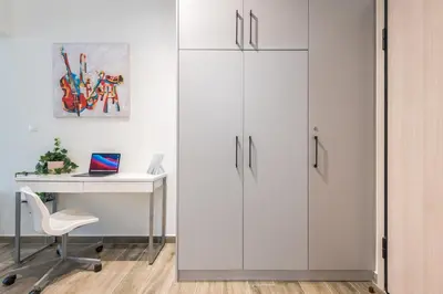 a white office with a desk and white cabinets at Kallithea Kyprou Square ! in Athens