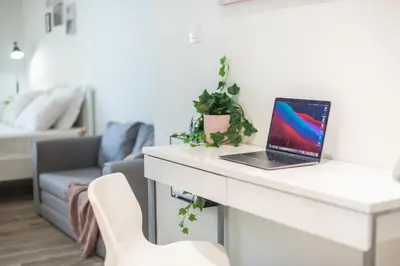 a laptop computer sitting on a white desk in a living room at Kallithea Kyprou Square ! in Athens