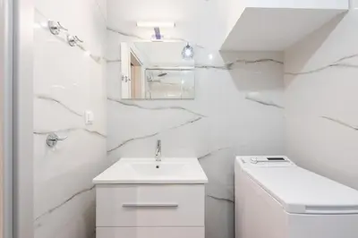 a white bathroom with a sink and a mirror at Kallithea Kyprou Square ! in Athens