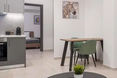 a kitchen with a table and a zebra picture on the wall at Oculus Kalithea Irakleous Apartments by Live&Travel in Athens