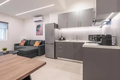 a kitchen and a living room with a couch at Oculus Kalithea Irakleous Apartments by Live&Travel in Athens