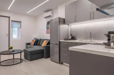 a kitchen and a living room with a couch at Oculus Kalithea Irakleous Apartments by Live&Travel in Athens