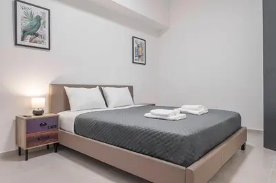 a bedroom with a bed with two towels on it at Oculus Kalithea Irakleous Apartments by Live&Travel in Athens