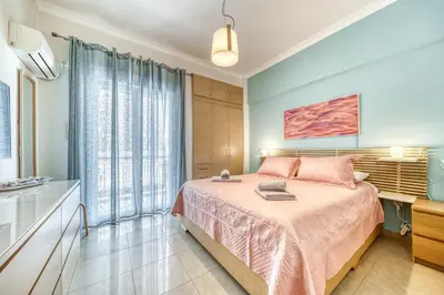 a bedroom with a bed with a pink bedspread at Manolias apartment in Athens