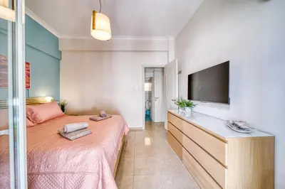 a bedroom with a bed and a flat screen tv at Manolias apartment in Athens