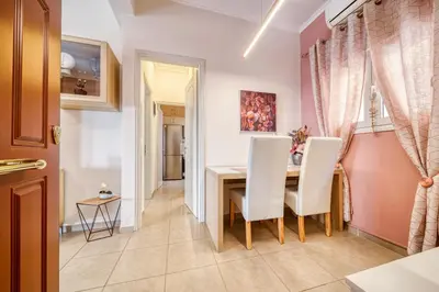 a dining room with a table and white chairs at Manolias apartment in Athens