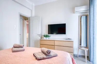 a white bedroom with a bed with towels on it at Manolias apartment in Athens