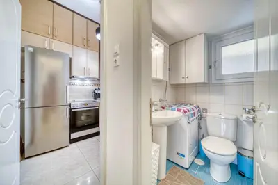 a bathroom with a toilet sink and a refrigerator at Manolias apartment in Athens