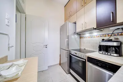 a kitchen with a stove and a refrigerator at Manolias apartment in Athens
