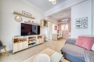 a living room with a couch and a tv at Manolias apartment in Athens