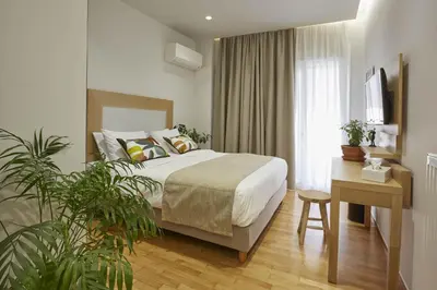 a hotel room with a bed and a table and plants at Filolaou Athens Luxury Apartment by Mystery in Athens
