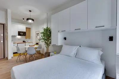 a bedroom with a large white bed and a kitchen at Historical center Athens amazing studio in Athens