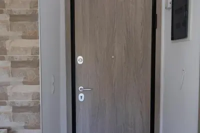a wooden door in front of a brick wall at The Pines apartment in Palaiá Fókaia