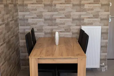 a wooden table with chairs and a vase on it at The Pines apartment in Palaiá Fókaia