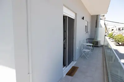 a balcony with a large window on the side of a building at The Pines apartment in Palaiá Fókaia
