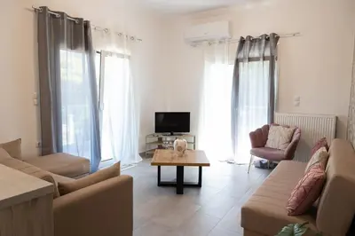 a living room with a couch and a table at The Pines apartment in Palaiá Fókaia
