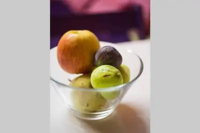 a glass bowl of apples and figs on a table at Inviting Flat near Acropolis in Athens