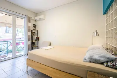 a bedroom with a large bed and a balcony at Inviting Flat near Acropolis in Athens