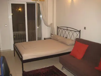 a bed and a couch in a room with a window at Μοντέρνος χώρος στο κέντρο της πόλης in Athens