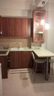 a kitchen with wooden cabinets and a table and a sink at Μοντέρνος χώρος στο κέντρο της πόλης in Athens