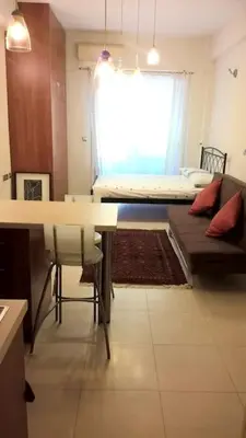 a living room with a table and a bed in a room at Μοντέρνος χώρος στο κέντρο της πόλης in Athens