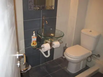 a bathroom with a toilet and a glass sink at Μοντέρνος χώρος στο κέντρο της πόλης in Athens