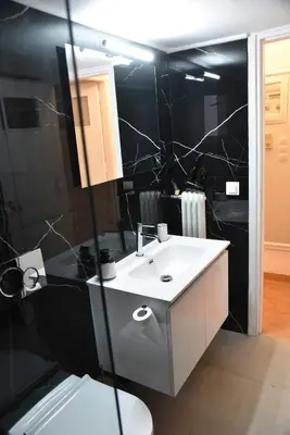 a bathroom with a white sink and a black wall at Ηλιόλουστο in Athens